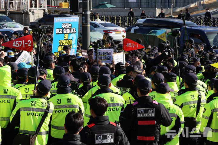 [서울=뉴시스] 이영환 기자 = 김유진 12.29 무안공항 제주항공 여객기참사 유가족협의회 대표와 유가족 등이 1일 오후 서울 용산구 대통령실 인근에서 열린 12.29 무안공항 제주항공 여객기참사 유가족협의회·시민사회 긴급 기자회견을 마친 후 이재명 대통령 면담 요청서 제출을 위해 이동하자 경찰이 막아서고 있다. 2025.12.01. 20hwan@newsis.com