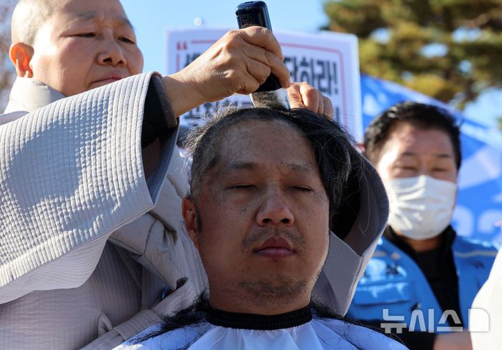 [서울=뉴시스] 이영환 기자 = 12.29 무안공항 제주항공 여객기참사 유가족들이 1일 오후 서울 용산구 대통령실 인근에서 열린 12.29 무안공항 제주항공 여객기참사 유가족협의회·시민사회 긴급 기자회견에서 삭발식을 하고 있다. 2025.12.01. 20hwan@newsis.com