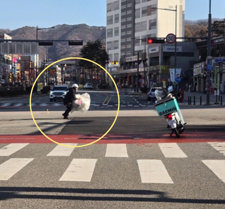 [뉴시스] 도로 한복판에 떨어진 대형 쓰레기를 배달기사가 직접 치우는 장면이 포착됐다. (사진 = 보배드림 갈무리) 2025.12.04. *재판매 및 DB 금지