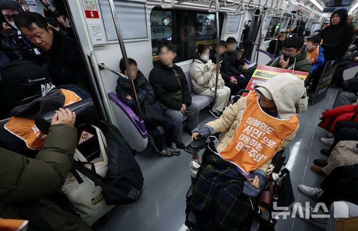 [서울=뉴시스] 이영환 기자 = 전국장애인차별철폐연대(전장연) 회원들이 4일 오전 서울 종로구 지하철5호선 광화문역에서 열린 '제67차 출근길 지하철 탑니다’ 시위에 참석하기 위해 5호선에 탑승해 광화문역에 도착하고 있다. 2025.12.04. 20hwan@newsis.com