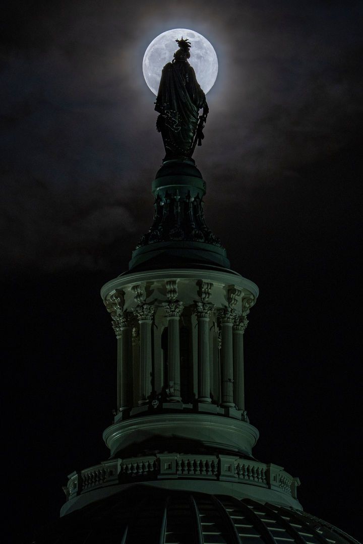 [워싱턴=AP/뉴시스] 4일(현지 시간) 미국 워싱턴에서 올해 마지막 보름달인 ‘콜드 슈퍼문’이 의사당 돔 꼭대기 '자유상'(Statue of Freedom) 뒤로 떠오르고 있다. 2025.12.05.