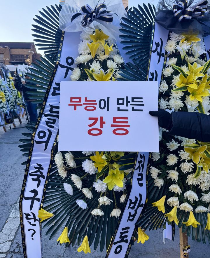 [대구=뉴시스] 정재익 기자 = 5일 오전 대구 중구 대구시청 동인청사 주차장에 대구 프로축구단 대구FC의 정상화를 요구하는 취지의 근조화환이 설치되고 있다.대구FC가 10년 만에 강등된 가운데 팬 서포터즈 연대 '그라지예'는 축구단을 둘러싼 각종 논란에 대한 쇄신을 요구하는 근조화환 시위를 벌였다. 2025.12.05. *재판매 및 DB 금지