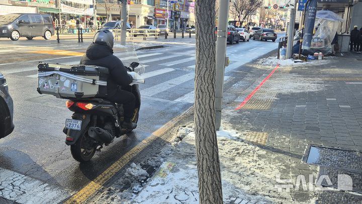 [서울=뉴시스]이종성 수습기자=5일 오전 서울 서대문구 홍제역 인근에서 배달기사가 빙판길 위 운전을 하고 있다. bsg05107@newsis.com 2025.12.05