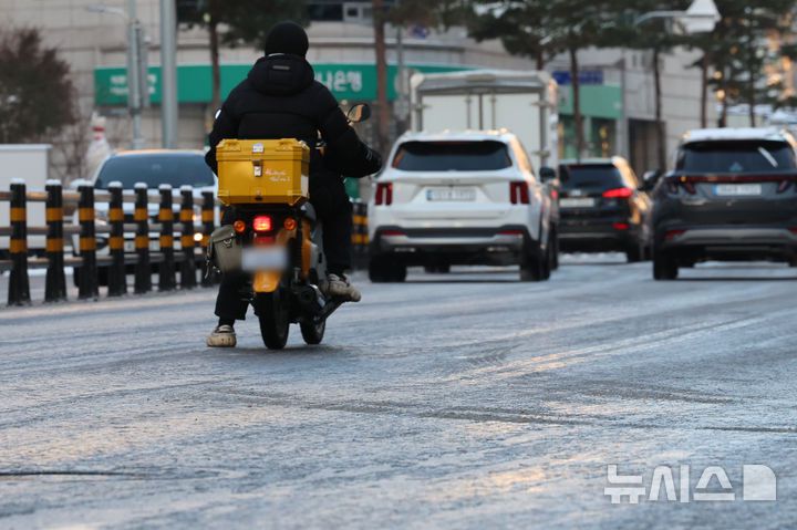 [서울=뉴시스] 권창회 기자 = 폭설 후 한파로 도로 곳곳이 얼어붙은 5일 오전 서울 중구 충무로역 인근에서 오토바이 운전자가 서행하고 있다. 2025.12.05. kch0523@newsis.com