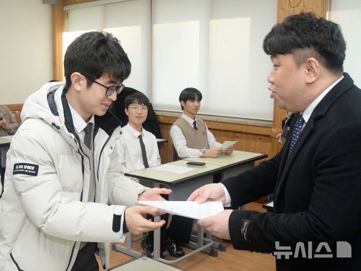 [전주=뉴시스] 김얼 기자 = 2026학년도 대학수학능력시험 성적표 배부일인 5일 전북 전주시 전주한일고등학교에서 수능 만점자 이하진(왼쪽) 학생이 선생님에게 성적표를 받고 있다. 2025.12.05. pmkeul@newsis.com