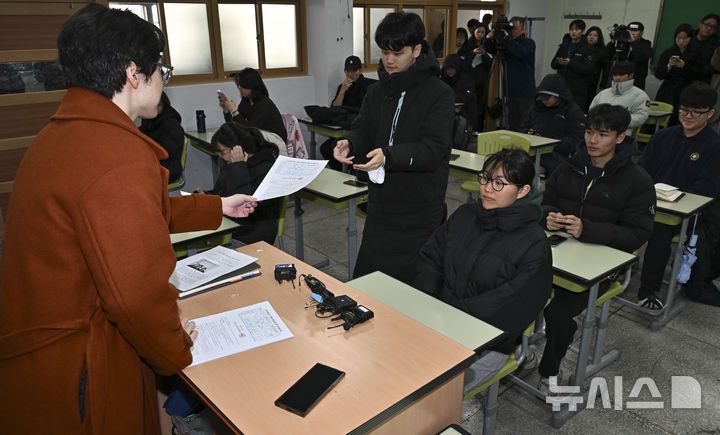 [서울=뉴시스] 홍효식 기자 = 2026학년도 대학수학능력시험(수능) 성적표가 배부된 5일 서울 광진구 광남고등학교에서 담임선생님이 수험생에게 성적표를 배부하고 있다. (공동취재) 2025.12.05. photo@newsis.com