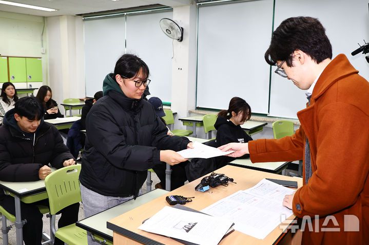 [서울=뉴시스] 홍효식 기자 = 2026학년도 대학수학능력시험(수능) 성적표가 배부된 5일 서울 광진구 광남고등학교에서 담임선생님이 수험생에게 성적표를 배부하고 있다. (공동취재) 2025.12.05. photo@newsis.com
