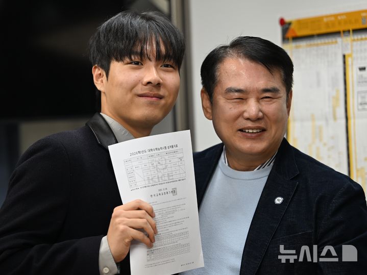 [광주=뉴시스]  5일 오전 광주 서구 서석고등학교에서 2026학년 대학수학능력시험에서 만점을 기록한 최장우 학생이 이정선 광주시교육청 교육감과 기념촬영을 하고 있다. 2025.12.05. lhh@newsis.com