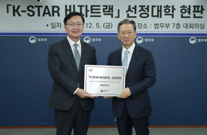 [서울=뉴시스] 정성호 법무부 장관이 5일 경기 과천시 정부과천청사에서 열린 'K-STAR 비자트랙 선정대학 현판 수여식'에 참석해 유홍림 서울대학교 총장에게 현판을 전달한 뒤 기념촬영 하고 있다. (사진=법무부 제공) 2025.12.05. photo@newsis.com *재판매 및 DB 금지