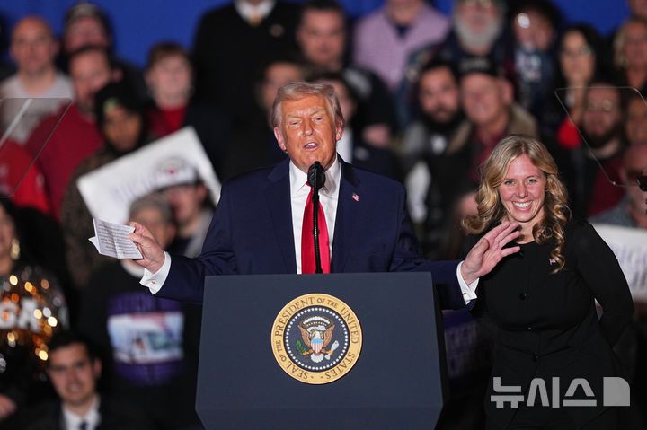 President Donald Trump reacts after Megan Hemhauser spoke at the Mount Airy Casino Resort in Mount Pocono, Pa., Tuesday, Dec. 9, 2025. (AP Photo/Matt Rourke)