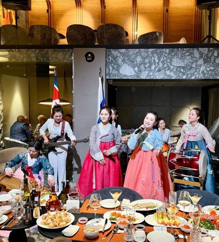 [서울=뉴시스] 지난달 26일 러시아 모스크바에 문을 연 북한 식당 ‘승리’ 개업식에서 러시아 국기와 북한 인공기가 뒤에 배치된 가운데 축하 공연이 열리고 있다.(출처: 주북 러시아 대사관 페이스북) 2025.12.15. *재판매 및 DB 금지