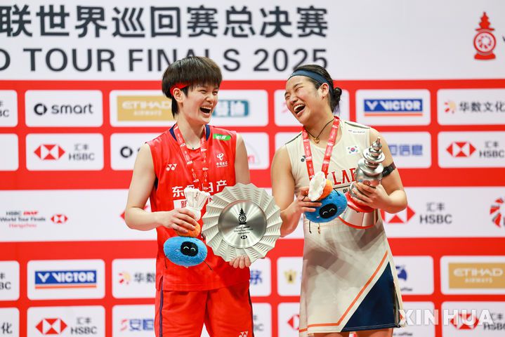 [항저우=신화/뉴시스] 안세영(오른쪽)이 21일(현지 시간) 중국 저장성 항저우 올림픽스포츠센터에서 열린 2025 세계배드민턴연맹(BWF) 월드투어 파이널스 여자 단식 정상에 올라 시상대에서 왕즈이(중국)와 함께 웃으며 포즈를 취하고 있다. 안세영은 결승에서 왕즈이를 2-1(21-13 18-21 21-10)로 꺾고 우승하며 시즌 11승을 달성했다. 2025.12.22.