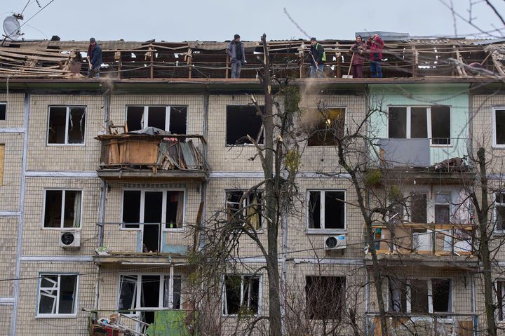 [키이우=AP/뉴시스] 지난 23일(현지 시간) 우크라이나 키이우에서 시청 소속 작업자들이 러시아의 드론 공습을 받은  아파트 건물을 정비하고 있다. 2025.12.27.