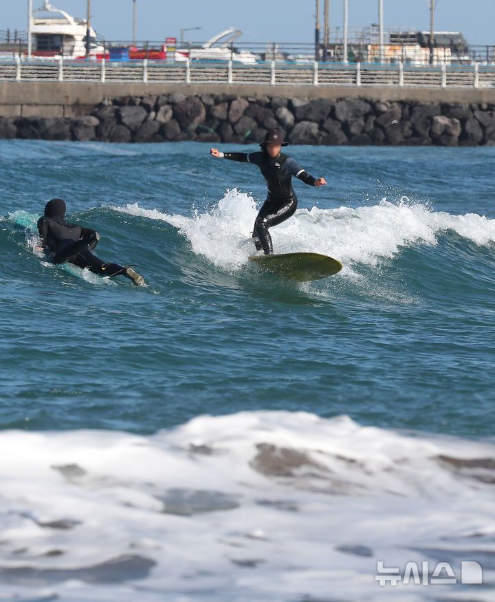 [제주=뉴시스] 우장호 기자 = 모처럼 맑은 날씨를 보인 6일 오전 제주시 이호테우해수욕장에서 레저객들이 서핑을 하고 있다. 2026.01.07. woo1223@newsis.com