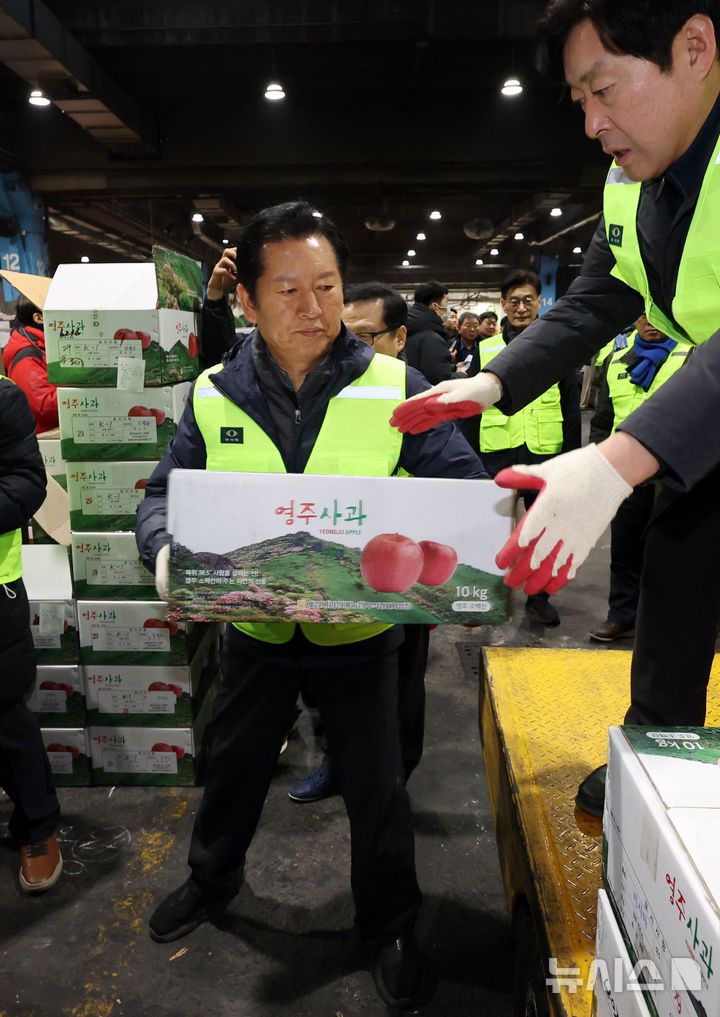 [서울=뉴시스] 조성우 기자 = 정청래(왼쪽) 더불어민주당 대표가 7일 오전 서울 송파구 가락동 농수산물 종합도매시장 중앙청과에서 경매를 마친 사과 상자를 운반차에 싣고 있다. 2026.01.07. xconfind@newsis.com