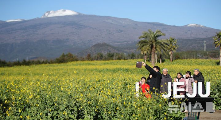 [서귀포=뉴시스] 우장호 기자 = 맑은 날씨를 보인 9일 오전 제주 서귀포시 남원읍 휴애리자연생활공원을 찾은 관광객들이 활짝 피어난 유채꽃을 감상하며 한겨울 속 봄 정취를 만끽하고 있다. 기상청에 따르면 주말인 10일부터 서서히 찬 대륙고기압의 영향을 받아 전국에 큰 추위가 찾아오고, 11일에는 남부와 제주를 중심으로 많은 눈이 내릴 것으로 예측됐다. 2026.01.09. woo1223@newsis.com