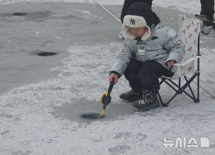 [화천=뉴시스]서백 기자=주말을 맞은 11일 화천산천어축제장을 찾은 한 아이가 산천어를 잡아 기뻐하고 있다. 2026.1.11. syi23@newsis.com