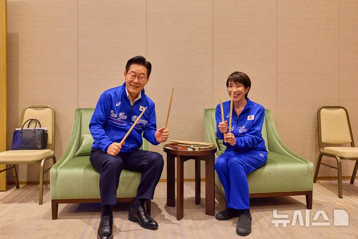 [나라=뉴시스] 고범준 기자 = 이재명 대통령이 다카이치 사나에 일본 총리와 함께 지난 13일 일본 나라현 회담장에서 일본 측이 마련한 푸른색 유니폼을 함께 착용하고 드럼 스틱을 들고 포즈를 취하고 있다. (공동취재) 2026.01.14. bjko@newsis.com