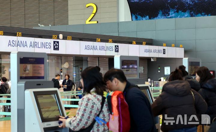[인천공항=뉴시스] 박주성 기자 = 아시아나항공이 인천공항 제2여객터미널 운항을 개시한 14일 인천국제공항 2터미널에서 승객들이 아시아나항공 카운터에서 출국수속을 하고 있다. 2026.01.14. park7691@newsis.com