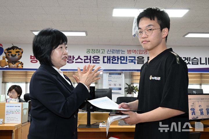 [서울=뉴시스] 권창회 기자 = 홍소영 병무청장이 15일 오전 서울 영등포구 서울지방병무청 제1병역판정검사장에서 열린 2026년도 병역판정검사에서 첫 현역 판정자를 축하해주고 있다. (공동취재) 2025.01.15. photo@newsis.com