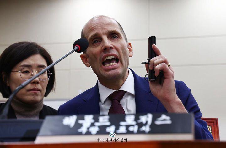 [서울=뉴시스] 뉴시스 김명년 기자가 15일 한국사진기자협회 2025년도 4분기 이달의 보도사진상 뉴스 부문에서 '동시통역기 싫다 화내는 해롤드 로저스 쿠팡 대표'로 우수상을 수상했다. 사진은 2025년 12월 30일 해롤드 로저스 쿠팡 대표이사가 서울 여의도 국회에서 열린 쿠팡 침해사고 및 개인정보 유출, 불공정 거래, 노동환경 실태 파악과 재발방지 대책 마련을 위한 연석 청문회에서 최민희 과방위원장의 동시통역기 착용 요구에 대해 입장을 밝히고 있다. (사진=한국사진기자협회 제공) 2026.01.15. photo@newsis.com *재판매 및 DB 금지