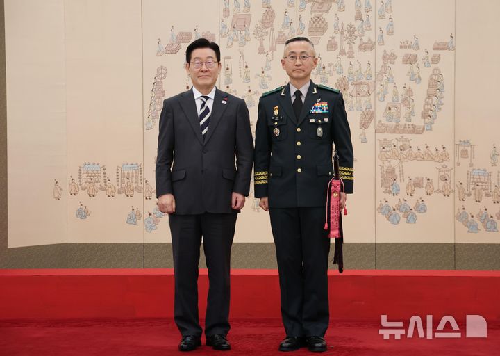 [서울=뉴시스] 고범준 기자 = 이재명 대통령이 16일 청와대 본관에서 열린 3성 장군 진급·보직 신고 및 수치 수여식에서 최성진 7군단장과 기념촬영 하고 있다. 2026.01.16. bjko@newsis.com