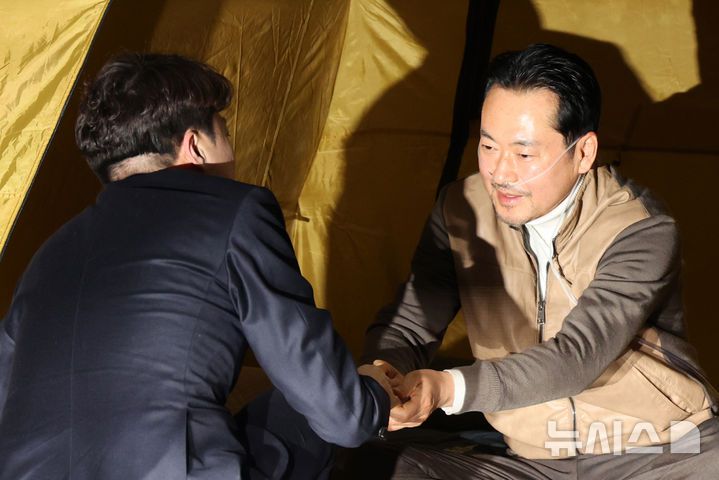 [서울=뉴시스] 김금보 기자 = 이준석 개혁신당 대표가 21일 오전 서울 여의도 국회 로텐더홀에서 '민주당 공천 뇌물·통일교 게이트 특검' 수용 촉구 단식투쟁을 하는 장동혁 국민의힘 대표를 찾아 악수하고 있다. 2026.01.21. kgb@newsis.com