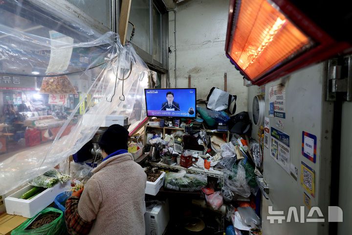 [서울=뉴시스] 김진아 기자 = 21일 서울 서대문구 인왕시장의 한 상점에 이재명 대통령의 신년 기자회견이 TV를 통해 생중계 되고 있다. 2026.01.21. bluesoda@newsis.com