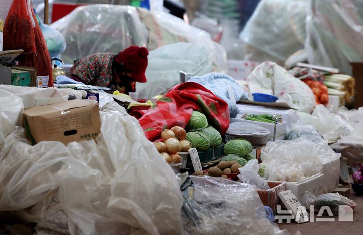 [서울=뉴시스] 김진아 기자 = 한파가 계속되고 있는 21일 서울 서대문구 인왕시장에서 상인들이 채소에 비닐과 이불을 덮어두고 있다. 2026.01.21. bluesoda@newsis.com