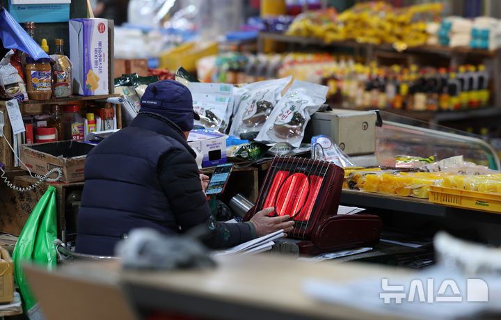 [서울=뉴시스] 김진아 기자 = 한파가 계속되고 있는 21일 서울 서대문구 인왕시장에서 상인들이 난로에 손을 녹이고 있다. 2026.01.21. bluesoda@newsis.com