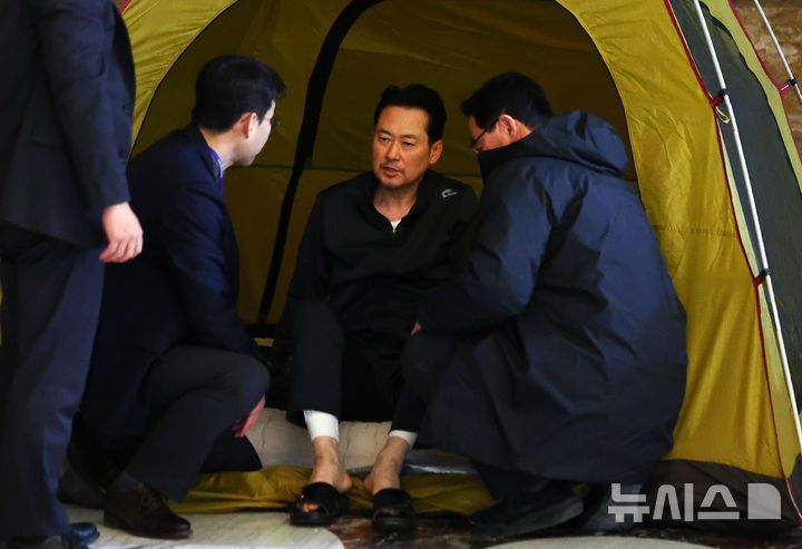 [서울=뉴시스] 김명년 기자 = 통일교·공천헌금 '쌍특검' 수용을 촉구하며 여드레째 단식중인 장동혁 국민의힘 대표가 21일 서울 여의도 국회 로텐더홀 농성장 텐트에서 일어나 당직자와 대화하고 있다. 2026.01.22. kmn@newsis.com