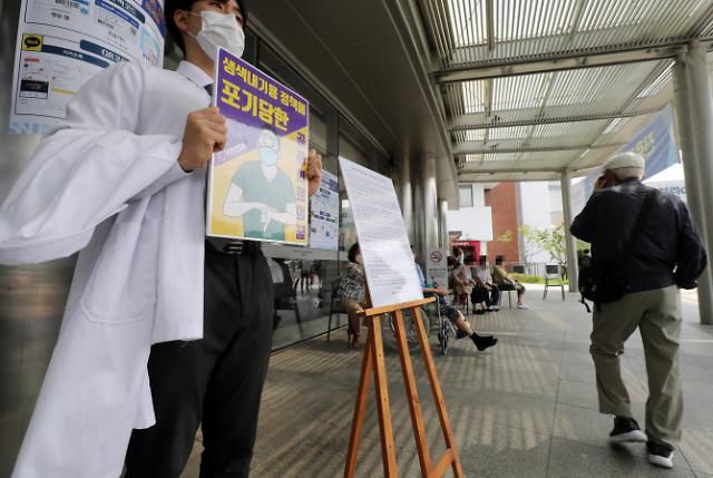 주요대학병원 전공의 파업을 하루 앞둔 20일 서울 종로구 서울대학병원 본관 앞에서 서울대 의대 3학년생이 의료계 현안 및 전공의 파업 지지 등의 내용이 담긴 성명문을 옆에 두고 릴레이 1인시위를 벌이고 있다.