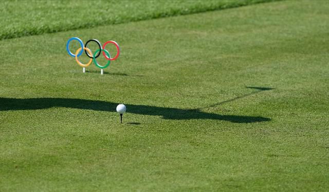 오륜기 티마커 옆에 공을 티 위에 올리고 스윙하는 선수