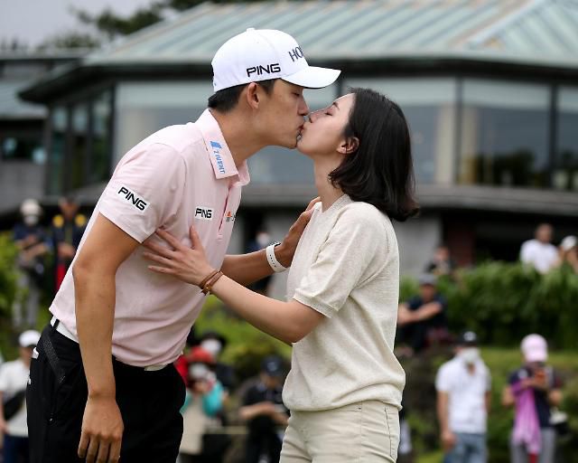 우승 직후 아내와 입 맞추는 김비오(왼쪽).