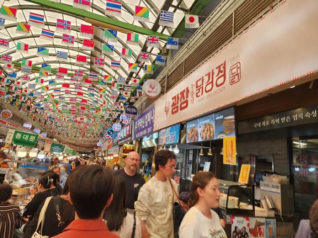 서울 종로구 광장시장에 위치한 광장 누룽지 닭강정 앞에 손님들도 북적이고 있다.