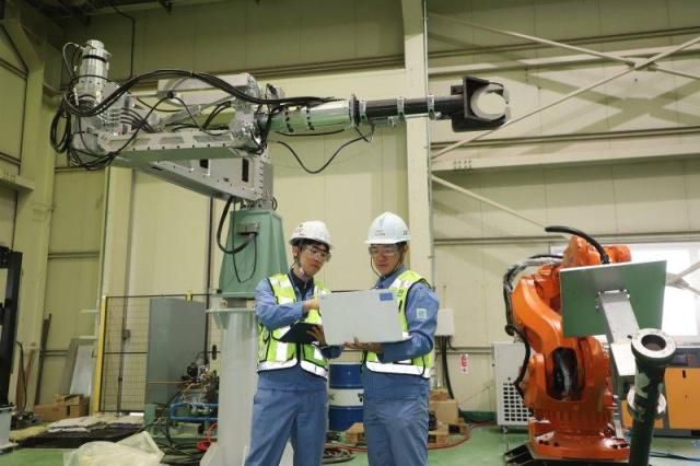 포스코DX 관계자들이 산업용 로봇을 현장에 적용하기 위해 로봇자동화 테스트를 준비하고 있다. [사진=포스코DX]