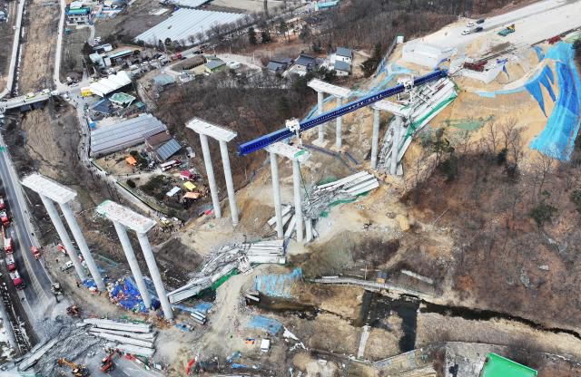 25일 경기도 안성시 서운면 산평리 소재 서울세종고속도로 천안~안성구간 9공구 천용천교 건설 현장에서 교량 연결작업 중 교각에 올려놓았던 상판이 무너지는 사고가 발생했다. [사진=연합뉴스]
