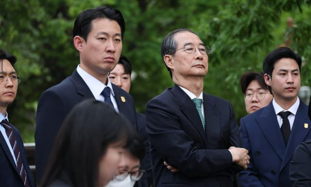 한덕수 무소속 대선 예비후보가 지난 8일 서울 국회 사랑재에 위치한 카페에서 회동을 마친 후 김문수 국민의힘 후보의 백프리핑을 듣고 있다. [사진=연합뉴스]