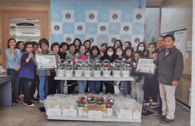 묵호노인종합복지관에서 고독사 예방사업 참여 어르신께 '카네이션 화분·롤케이크'을 전달하고 있다. [사진=묵호노인종합복지관]