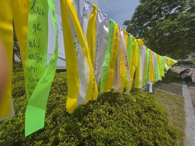 18일 광주 북구 국립 5.18 민주묘지 앞에 노란 추모 리본이 일렬로 매달려 있다. 이 중에서 '윤석열 구속' 이라는 내용이 적힌 리본도 보인다. [사진=신진영 기자]