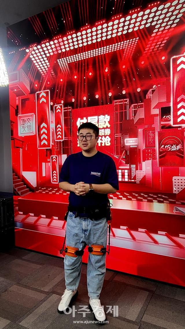 중국 저장성 항저우 현지 AI로봇업체인 청톈커지 창업주가 직접 '외골격 로봇'을 착용해 설명하고 있다. [사진=배인선 기자]