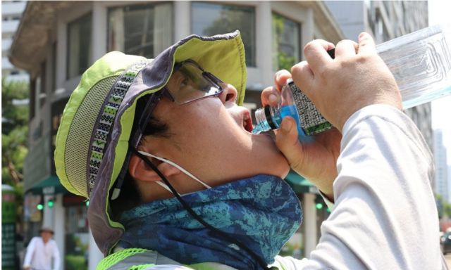 7일 오전 대구 북구 침산동 일대에서 환경공무직 김건이(33)씨가 잠시 청소를 멈추고 이온 음료를 마시고 있다. 대구기상청에 따르면 이날 오후 2시를 기준으로 대구는 최고기온 37.3도를 기록했다.[사진=연합뉴스]