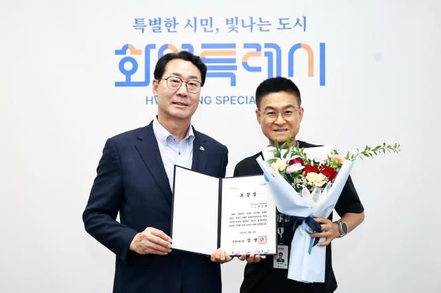 정명근 화성특례시장(좌)과 정동헌 주무관(우)이 기념촬영을 하고 있다. [사진=화성시]