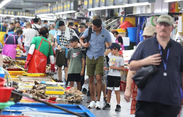 지난 8월 21일 부산 중구 자갈치시장을 찾은 외국인 관광객들이 시장을 둘러보며 수산물을 고르고 있다. [사진=연합뉴스]