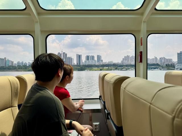 한강버스 탑승객들이 창문을 통해 한강의 풍경을 바라보고 있다. [사진=강상헌 기자]