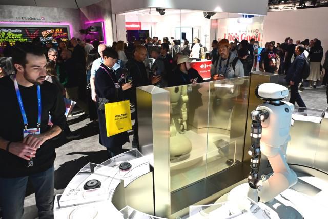 Visitors experience LG Electronics’ home robot “LG Cloi” and its actuator brand “LG Actuator Axiom” at CES 2026 in Las Vegas on Jan. 6, showcasing proactive home-care capabilities such as laundry assistance and towel organization/