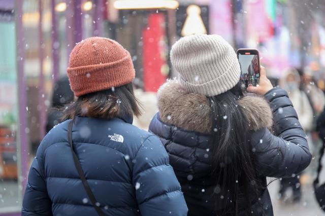 Tourists enjoy heavy snowfall in Myeong-dong, central Seoul, on Jan. 12, 2026. AJP Yoo Na-hyun