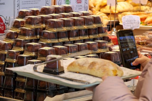 A customer purchasing Dubai Chewy Cookies at a bakery in Jongno District, central Seoul, on January 12. AJP Yoo Na-hyun