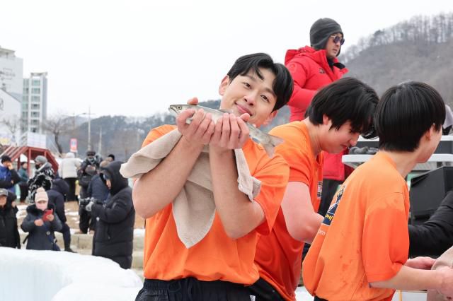 A participant holds a mountain trout after the bare-hand fishing competition at the Hwacheon Sancheoneo Ice Festival in Hwacheon, Gangwon Province. Jan. 12, 2026. AJP Han Jun-gu