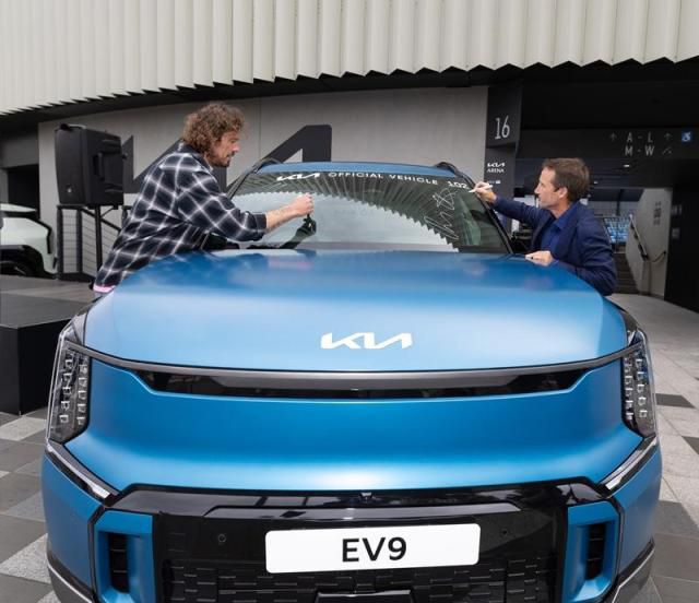 대회공식차량 중 EV9에 사인하고 있는 러시아 테니스 레전드 마라트 사핀과 호주 경마 레전드이자 기아 호주법인 앰버서더 데이미언 올리버 [사진=현대차]
